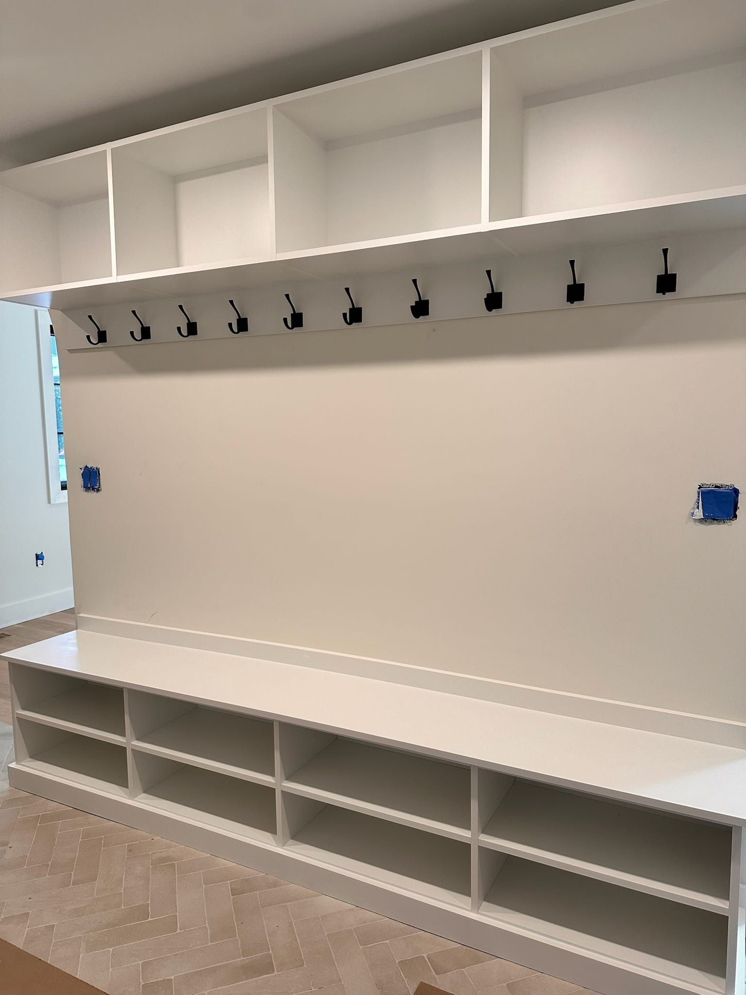 Mud room storage solutions with coat hooks, bench and under storage